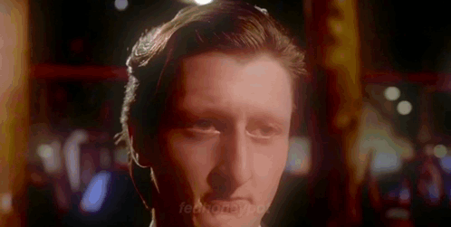 A Close Up Of A Man 'S Face In A Dark Room With A Blurred Background GIF