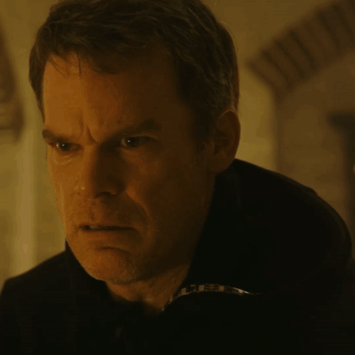 A Close Up Of A Man 'S Face In A Dark Room With A Blurry Background GIF
