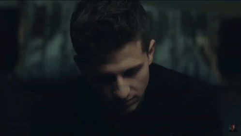 A Close Up Of A Man 'S Face In A Dark Room With A Blurry Background . GIF