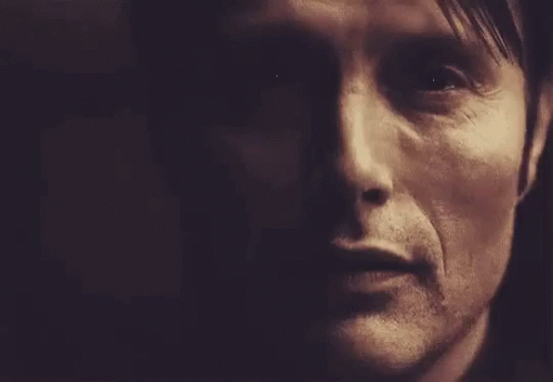 A Close Up Of A Man 'S Face In A Dark Room With A Dark Background . GIF