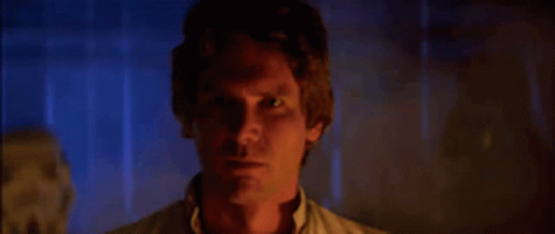 A Close Up Of A Man 'S Face In A Dark Room With Smoke Coming Out Of His Eyes . GIF