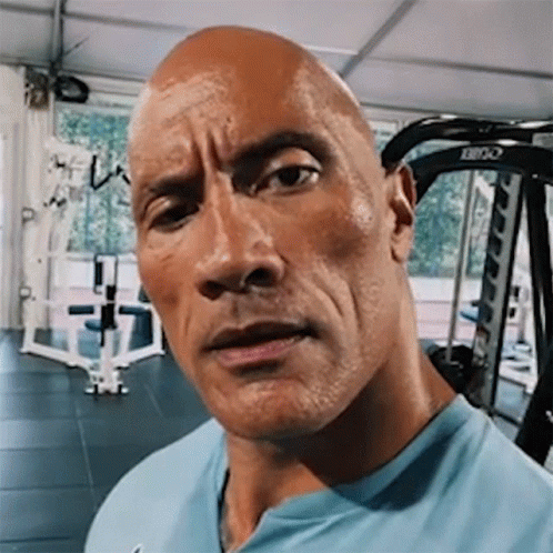 A Close Up Of A Man 'S Face In A Gym With A Machine In The Background . GIF