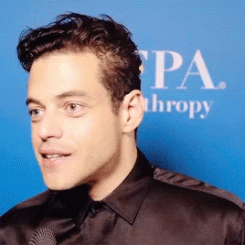 A Close Up Of A Man 'S Face In Front Of A Sign That Says Pa Thropy GIF