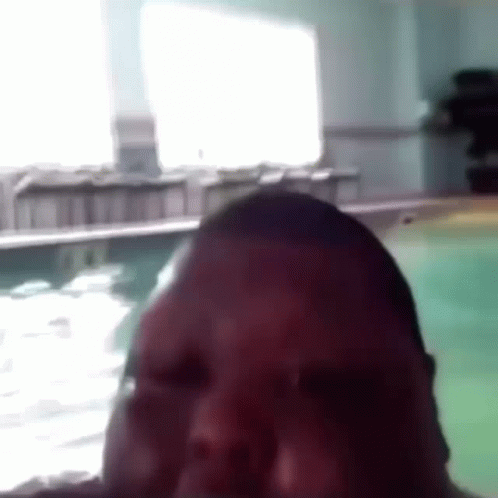 A Close Up Of A Man 'S Face In Front Of A Swimming Pool . GIF