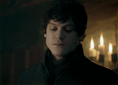 A Close Up Of A Man 'S Face In Front Of Candles GIF