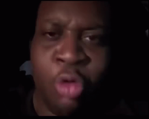 A Close Up Of A Man 'S Face In The Dark With A Blurred Background . GIF
