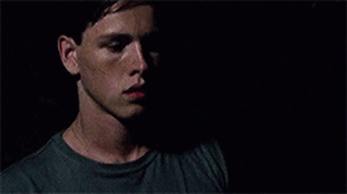 A Close Up Of A Man 'S Face In The Dark With A Shadow On His Face . GIF