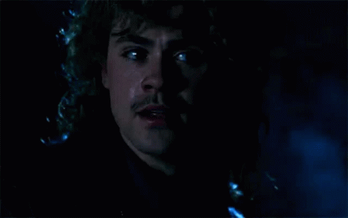 A Close Up Of A Man 'S Face In The Dark With Tears Coming Out Of His Eyes . GIF