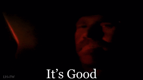 A Close Up Of A Man 'S Face In The Dark With The Words `` It 'S Good '' Written Below It . GIF