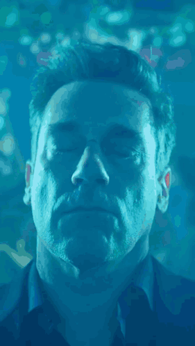 a close up of a man 's face in the water with his eyes closed