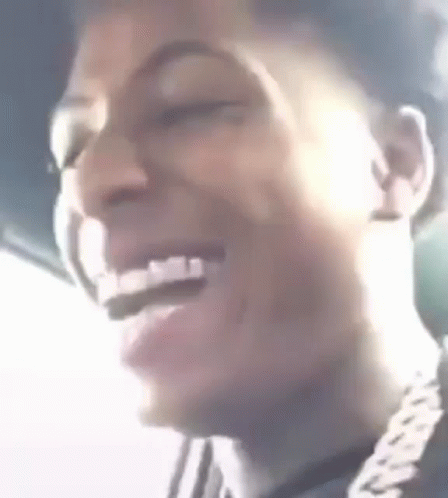 A Close Up Of A Man 'S Face Laughing With His Eyes Closed And A Chain Around His Neck . GIF