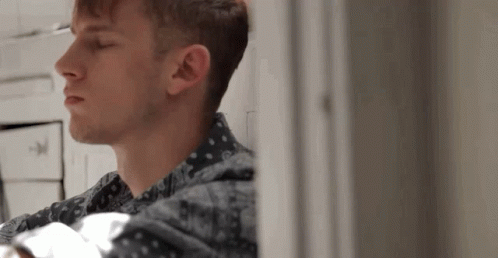 A Close Up Of A Man 'S Face Looking Out A Window GIF