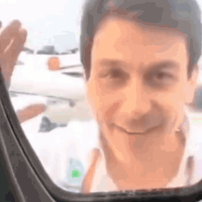 A Close Up Of A Man 'S Face Looking Out Of A Car Window . GIF