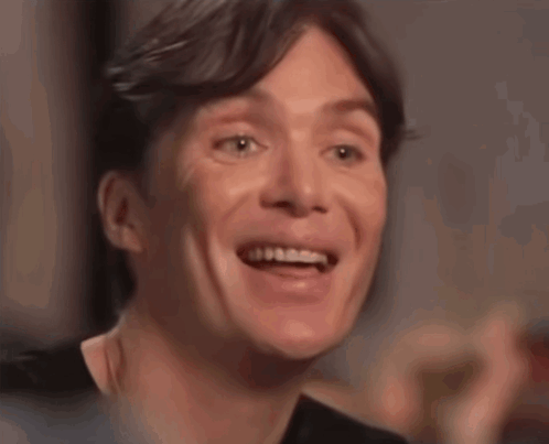 A Close Up Of A Man 'S Face Smiling With His Mouth Open GIF