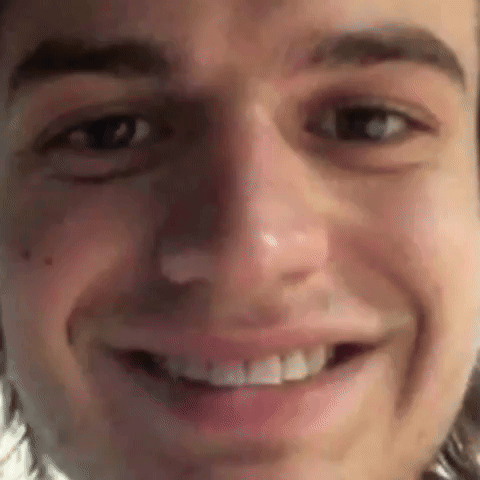 A Close Up Of A Man 'S Face Smiling With His Mouth Open . GIF