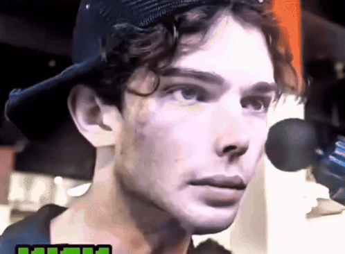 a close up of a man 's face wearing a baseball cap