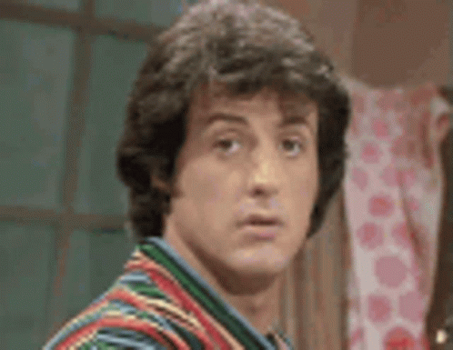 A Close Up Of A Man 'S Face Wearing A Colorful Shirt . GIF
