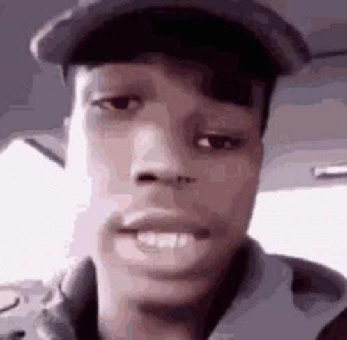 A Close Up Of A Man 'S Face Wearing A Hat And A Jacket . GIF