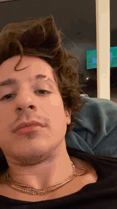 A Close Up Of A Man 'S Face Wearing A Necklace GIF