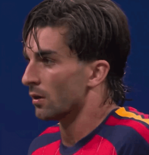 A Close Up Of A Man 'S Face Wearing A Red And Blue Shirt GIF