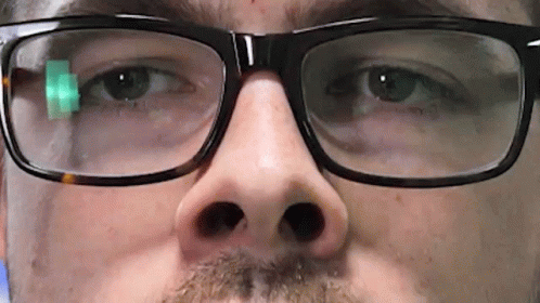 A Close Up Of A Man 'S Face Wearing Glasses And A Beard GIF