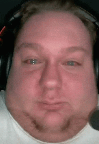 A Close Up Of A Man 'S Face Wearing Headphones And A White Shirt GIF