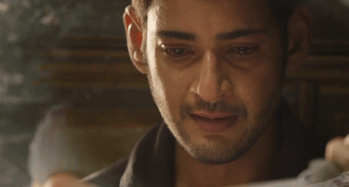 A Close Up Of A Man 'S Face While Looking At A Piece Of Paper . GIF