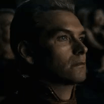 A Close Up Of A Man 'S Face While Watching A Movie In A Dark Room . GIF