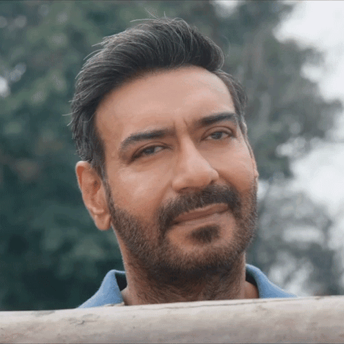 A Close Up Of A Man 'S Face With A Beard And A Blue Shirt GIF