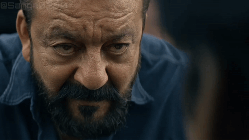 A Close Up Of A Man 'S Face With A Beard And A Blue Shirt With A Watermark That Says @Sanjeev GIF