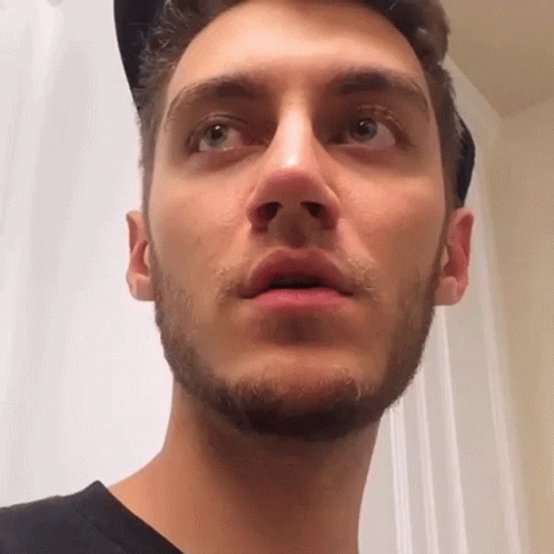 A Close Up Of A Man 'S Face With A Beard And A Hat On . GIF