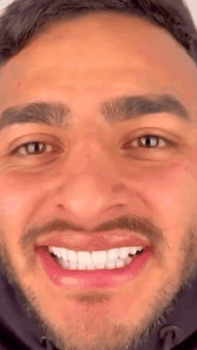 A Close Up Of A Man 'S Face With A Beard And A Smile On His Face . GIF
