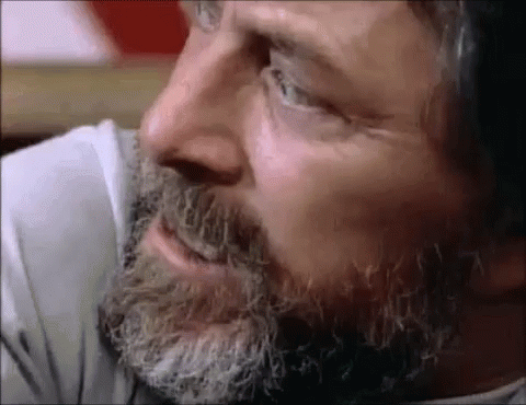 A Close Up Of A Man 'S Face With A Beard And A White Shirt GIF