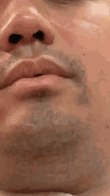 A Close Up Of A Man 'S Face With A Beard And Black Eyes GIF