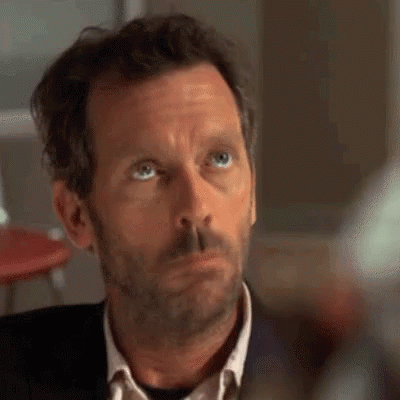 A Close Up Of A Man 'S Face With A Beard And Blue Eyes Looking Up . GIF