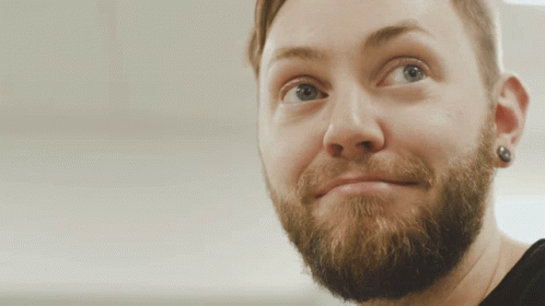 A Close Up Of A Man 'S Face With A Beard And Earring GIF