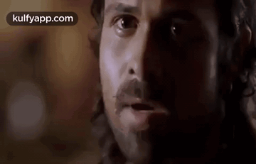 A Close Up Of A Man 'S Face With A Beard And Mustache Looking At The Camera . GIF