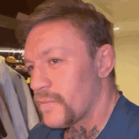 A Close Up Of A Man 'S Face With A Beard And Tattoos . GIF