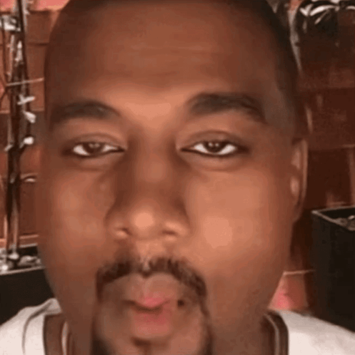 A Close Up Of A Man 'S Face With A Beard Blowing A Kiss GIF