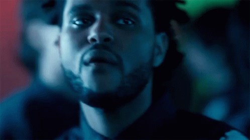 A Close Up Of A Man 'S Face With A Beard In A Dark Room GIF