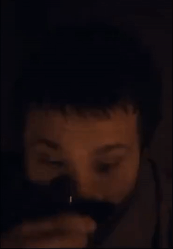 a close up of a man 's face with a beard in the dark