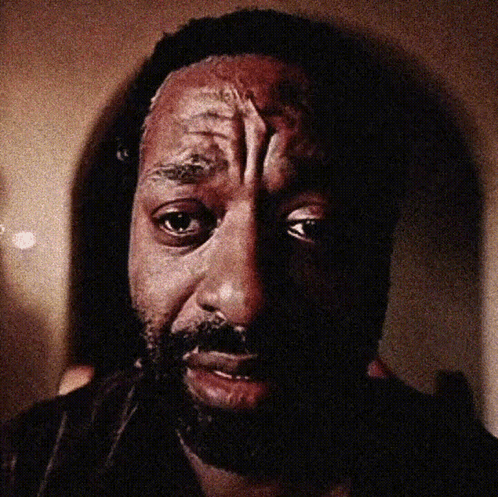 A Close Up Of A Man 'S Face With A Beard Looking At The Camera GIF