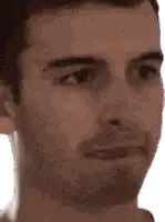 a close up of a man 's face with a beard looking at the camera on a white background .