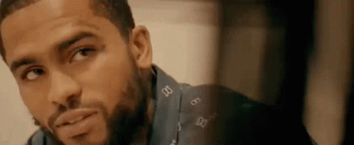 A Close Up Of A Man 'S Face With A Beard Wearing A Blue Shirt . GIF