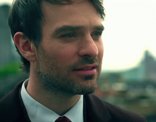 A Close Up Of A Man 'S Face With A Beard Wearing A Suit And Tie GIF