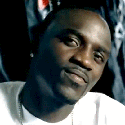 A Close Up Of A Man 'S Face With A Beard Wearing A White Shirt And A Necklace . GIF