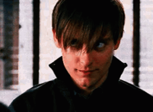 A Close Up Of A Man 'S Face With A Black Jacket On Looking At The Camera . GIF