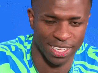 A Close Up Of A Man 'S Face With A Blue And Green Shirt On GIF
