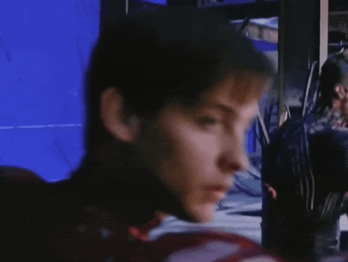 A Close Up Of A Man 'S Face With A Blue Screen Behind Him GIF