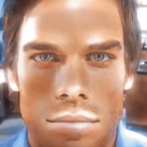 A Close Up Of A Man 'S Face With A Blue Shirt GIF